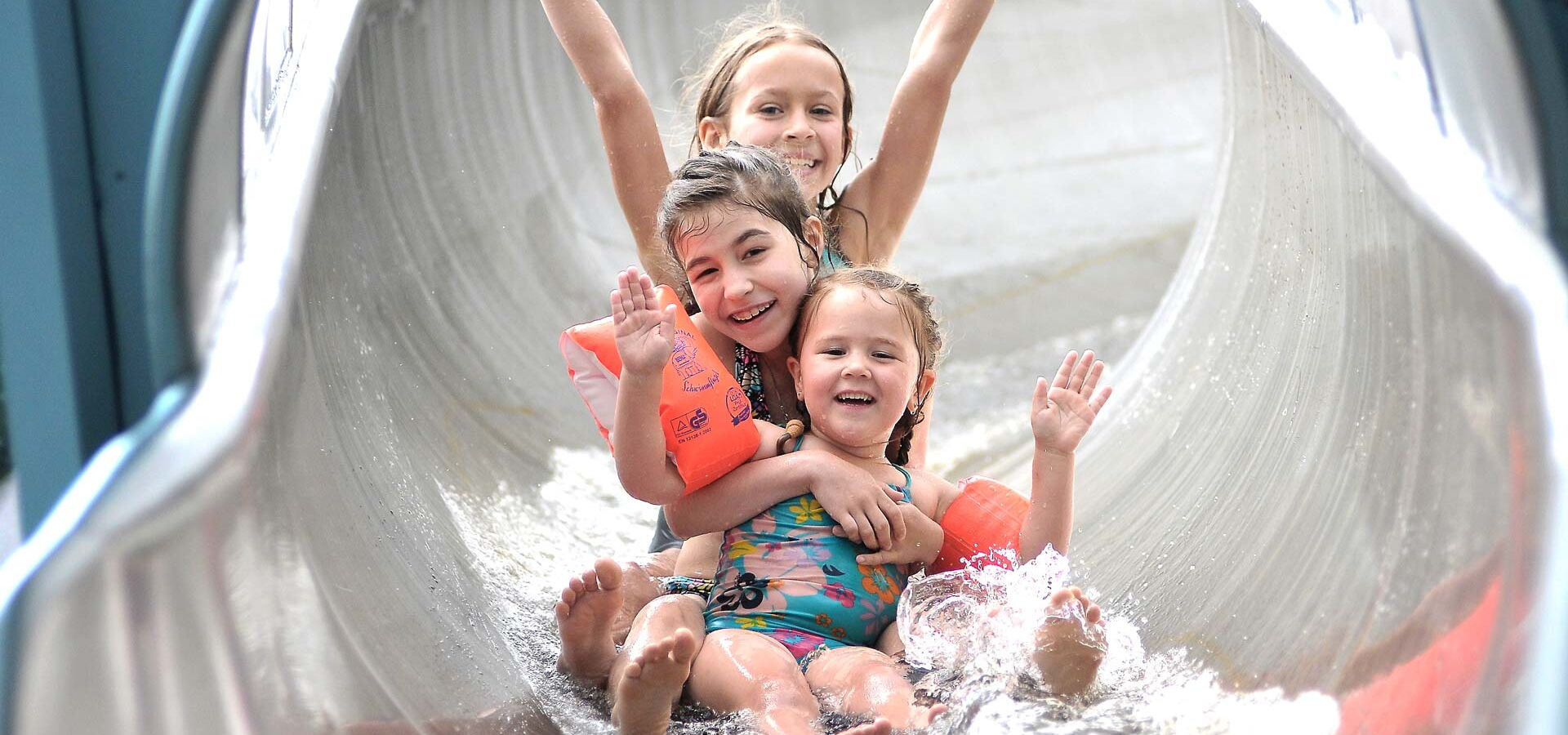 Drei Mädchen rutschen runter von der Riesenrutsche