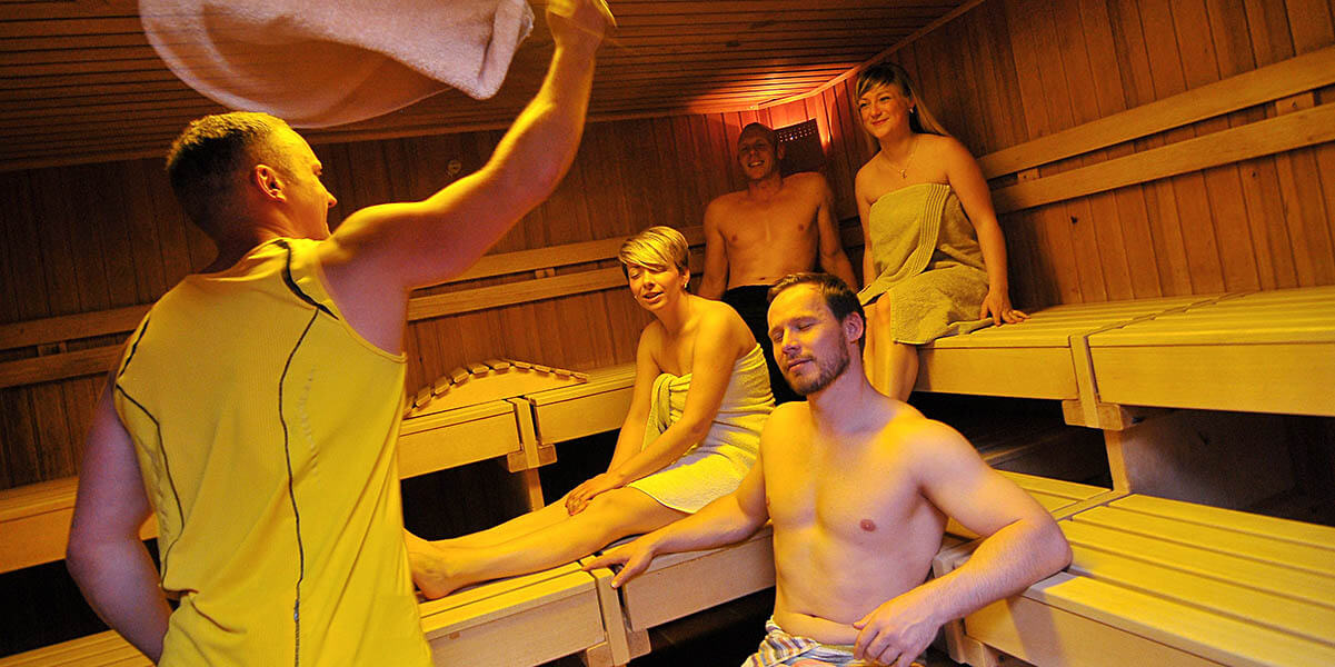 Sauna - Slider - Junge Menschen entspannen sich im Sauna und genießen den Saunaaufguss